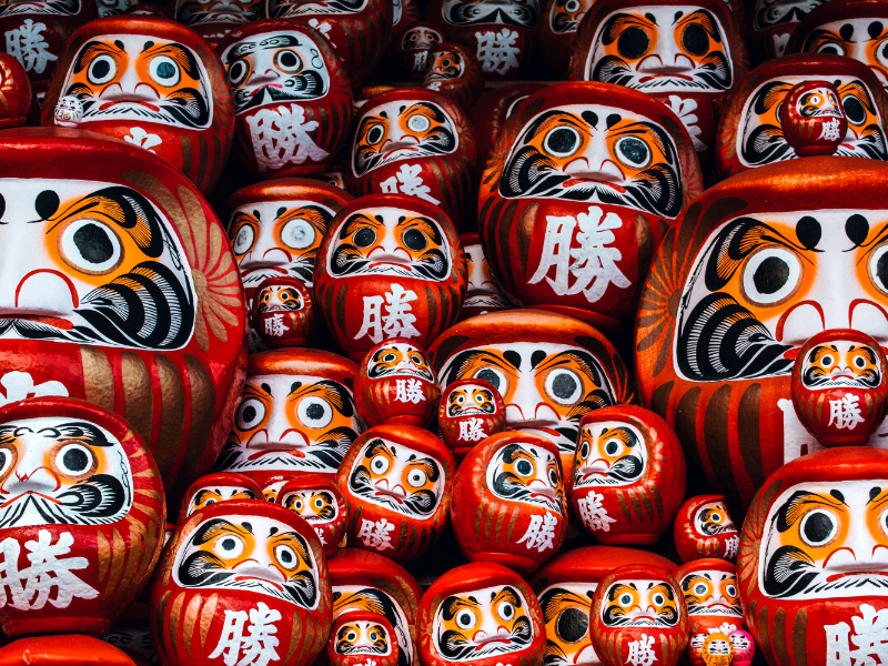 15 porte-bonheurs japonais pour attirer la chance - Montage de Daruma aux visages sévères - Photo de Roméo A. sur Unsplash