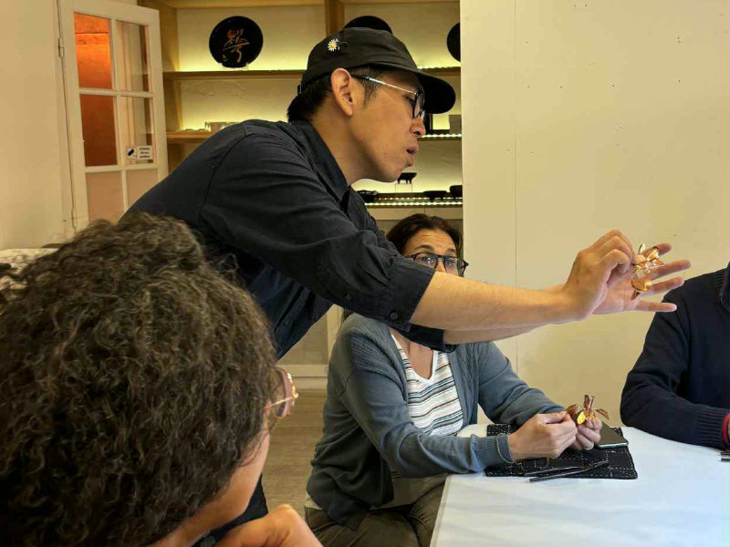 TAichi YAmagata en train d'animer un atelier de réalisation de mini casque samouraï en cuivre et laiton