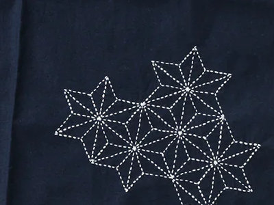 Motif asanoha r&eacute;alis&eacute; en sashiko sur un textile teint&eacute; &agrave; l'indogo naturel, vu &agrave; Takayama (Gifu)