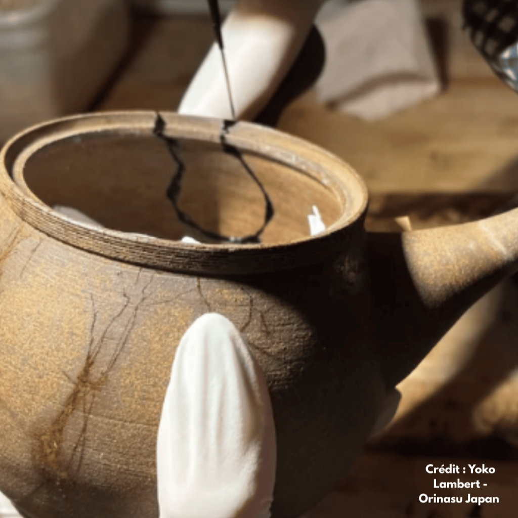 Pose de la laque urushi sur la f&ecirc;lure d&rsquo;une tasse en c&eacute;ramique comme premi&egrave;re &eacute;tape du kintsugi - artiste : yoko lambert - source : orinasujapan.com
