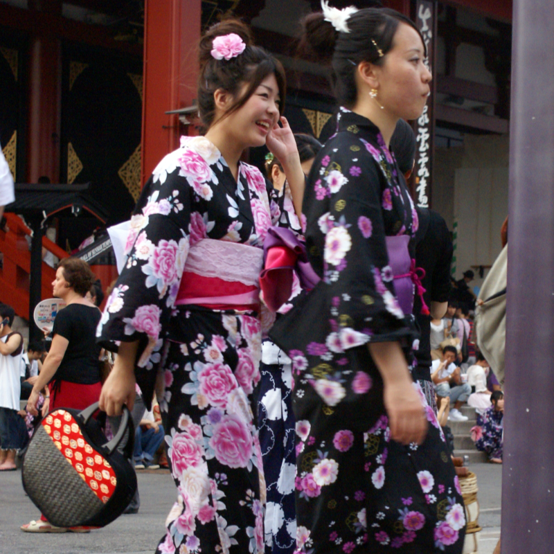 Deux Japonaises portant des yukatas noirs aux motifs fleuris marchant dans les rues de Tokyo
