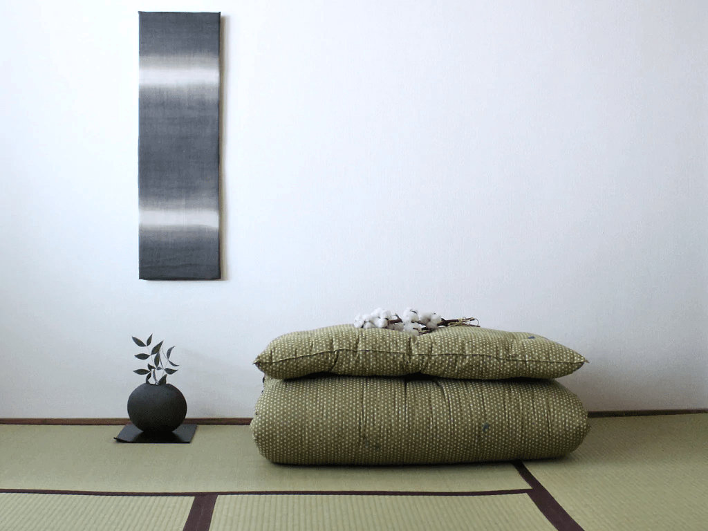 Shiki futon plié sur tatami composant le véritable futon japonais — source site officiel de l’atelier Takaokaya