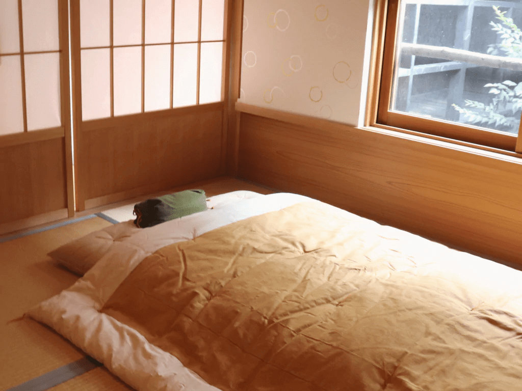 Véritable futon japonais et sa couette kake futon posé sur des tatamis — source atelier takaokaya