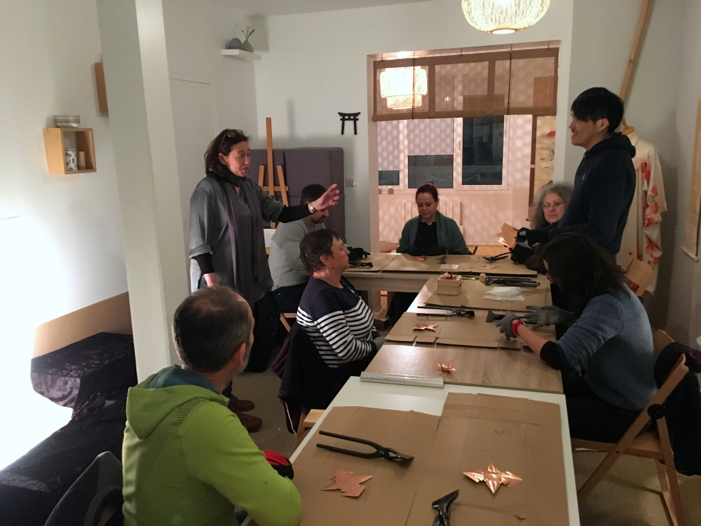 maitre Uchino expliquanbt la réalisation d'une grue origami en cuivre