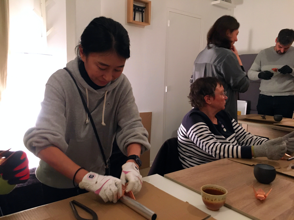 Kaori Uchino aidant à la formation du corps de la grue en cuivre.
