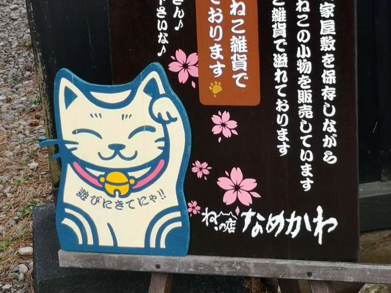 15 porte-bonheurs japonais pour attirer la chance - Panneau d’affichage avec un maneki neko tout mignon qui invite le client à entrer - Photo tirée du Konjakuryoko de 2019